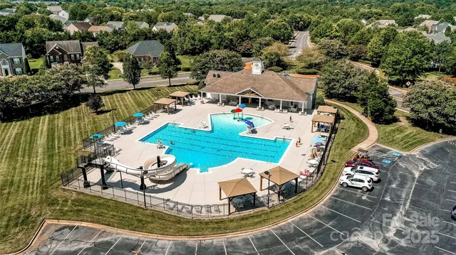 an aerial view of a house with a garden and lake view