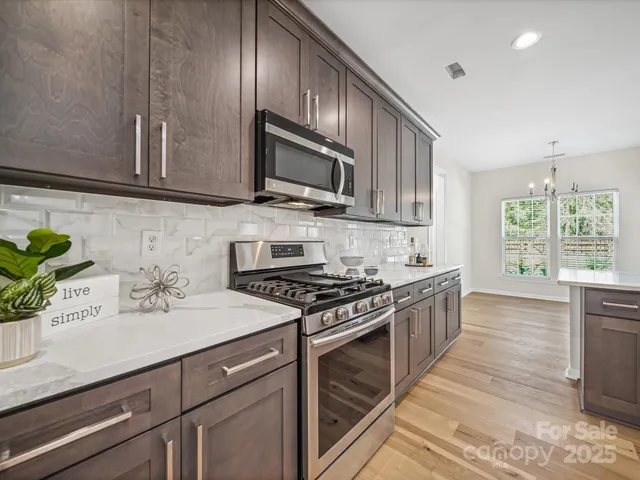a kitchen with stainless steel appliances a sink stove and cabinets