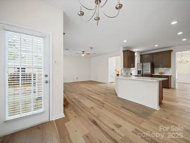 a view of kitchen with center island wooden floor and electronic appliances