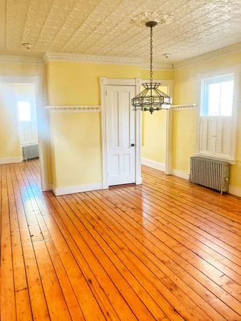 a view of a room with wooden floor windows and chandelier