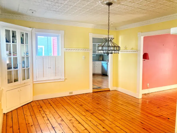 a view of empty room with wooden floor and windows