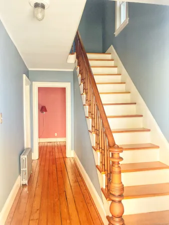 a view of entryway and hall with wooden floor