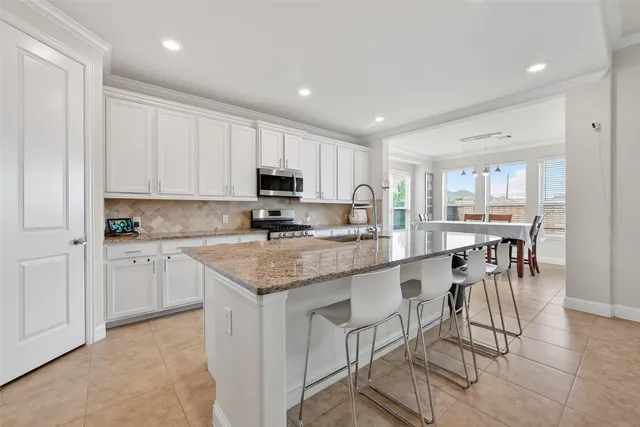 a kitchen with stainless steel appliances granite countertop a sink stove and microwave