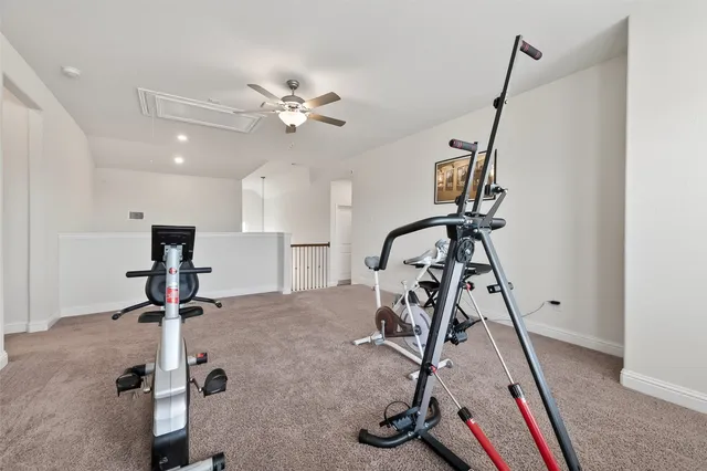 an empty room with a chandelier fan and windows