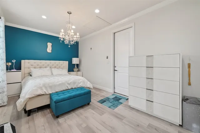 a bedroom with a large bed and a chandelier