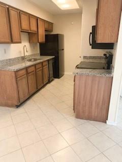 Gallley kitchen with granite counterops and black apppliances including glass cooktop and builtin microwave. Dishwasher was replaced last year.