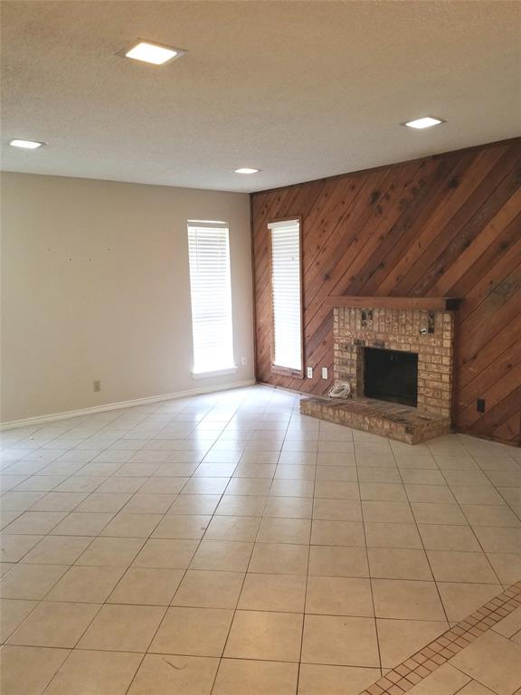 407 Gatewood Road, Unit 407 Garland, TX 75043 - Photo 2 of 6 Living room with cozy woodburning fireplace and cedar accent wall.