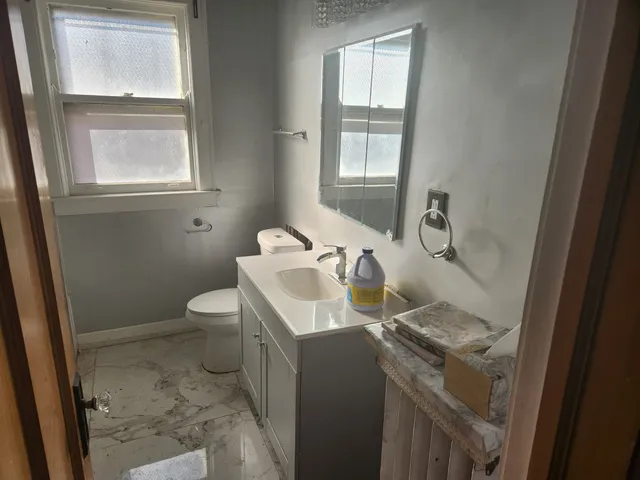 a bathroom with a sink toilet and window