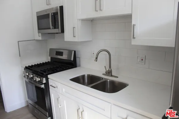 a kitchen with stainless steel appliances granite countertop a sink and a stove