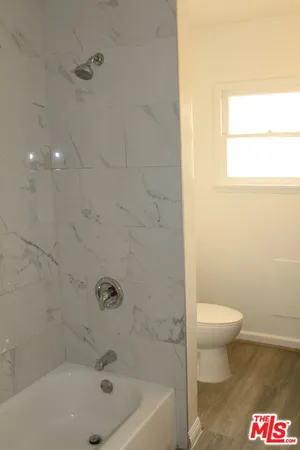 a bath room with a toilet and a bath tub