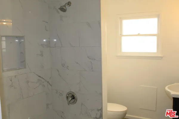 a bathroom with a toilet a sink and a shower