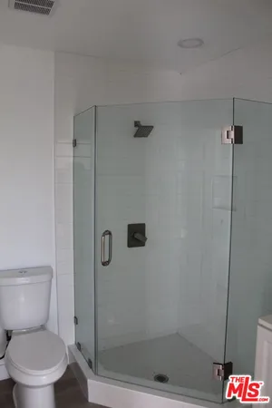 a white toilet next to a shower