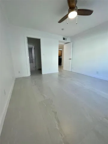 an empty room with an empty space and a ceiling fan