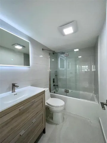 a bathroom with a bathtub shower sink mirror and toilet