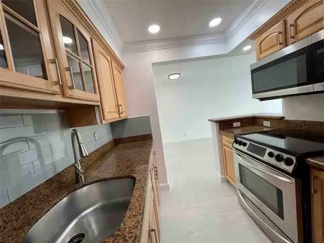 a kitchen with granite countertop a stove and a sink