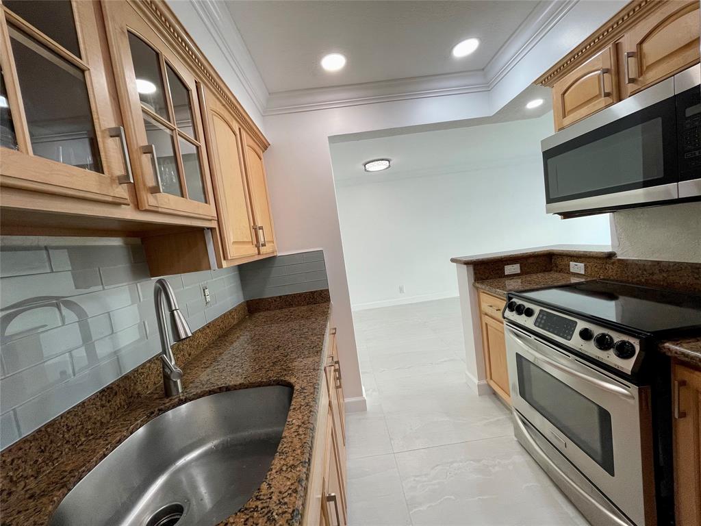 1515 East Broward Boulevard, Unit 124 Fort Lauderdale, FL 33301 - Photo 9 of 12 a kitchen with granite countertop a stove and a sink