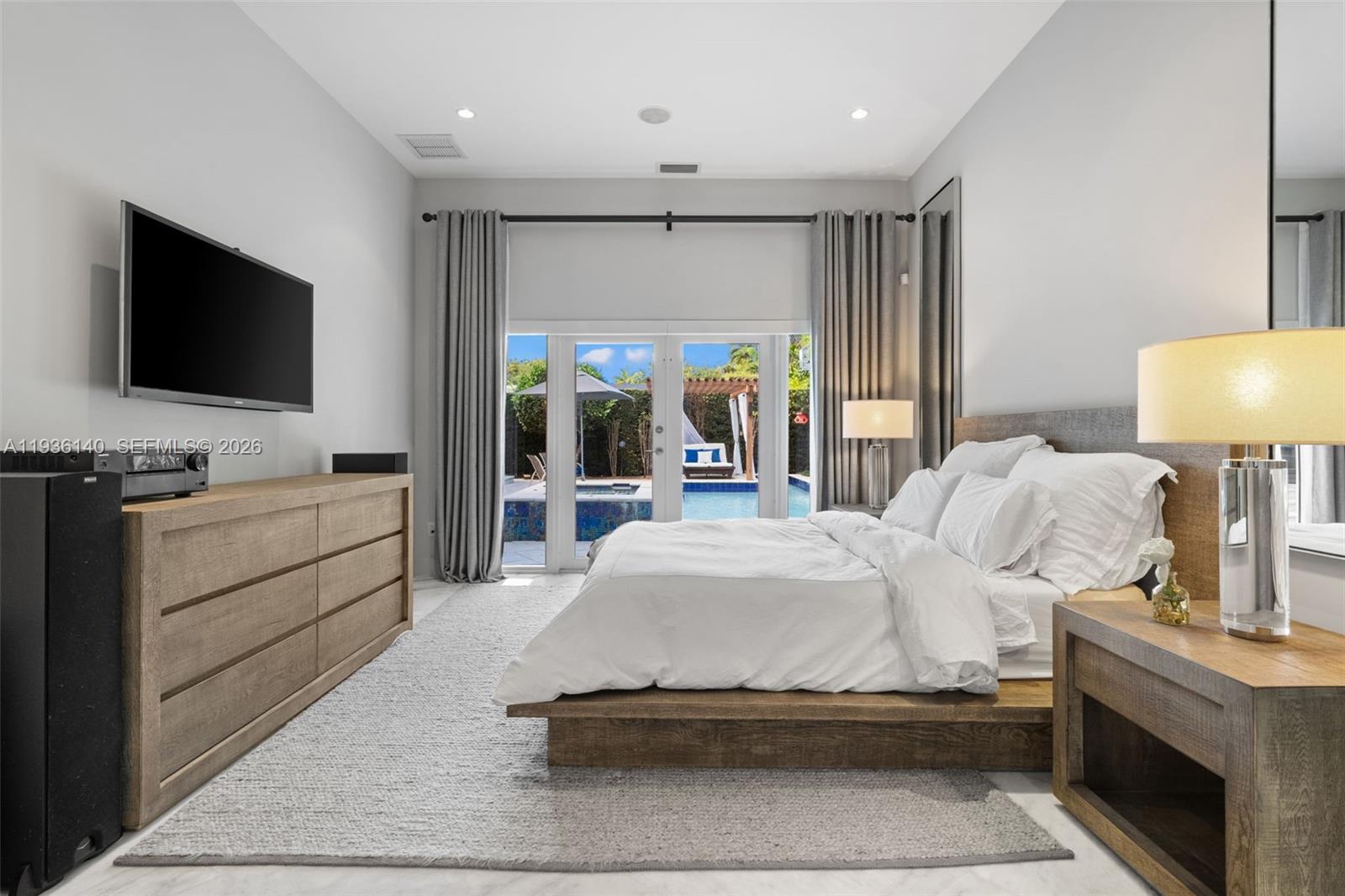 1251 Kane Concourse Bay Harbor Islands, FL 33154 - Photo 16 of 52 a spacious bedroom with a bed and a flat tv screen