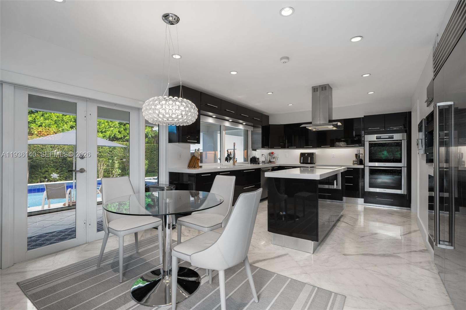 1251 Kane Concourse Bay Harbor Islands, FL 33154 - Photo 23 of 52 a large kitchen with a table and chairs