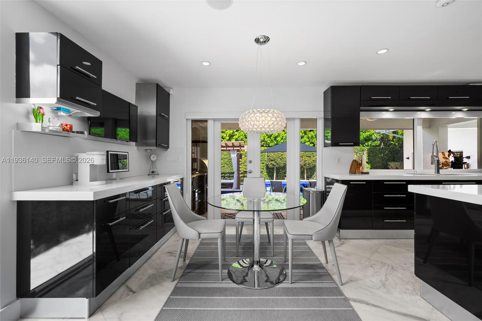 1251 Kane Concourse Bay Harbor Islands, FL 33154 - Photo 24 of 52 a kitchen with stainless steel appliances granite countertop a stove a sink a refrigerator and a dining table with wooden floor