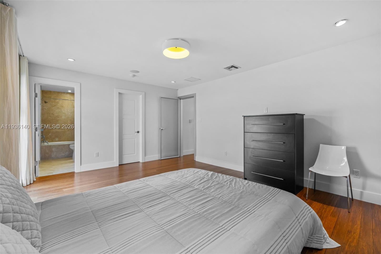 1251 Kane Concourse Bay Harbor Islands, FL 33154 - Photo 28 of 52 a bedroom with a bed and a lamp on table