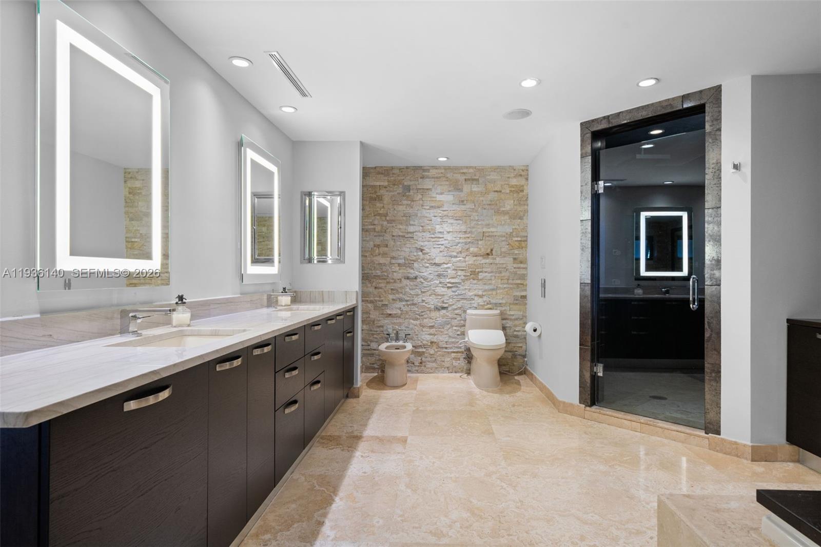 1251 Kane Concourse Bay Harbor Islands, FL 33154 - Photo 37 of 52 a spacious bathroom with a double vanity sink toilet and shower