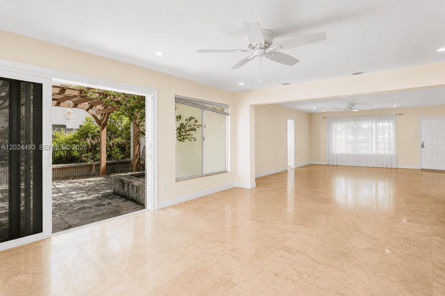 1995 Ixora Road North Miami, FL 33181 - Photo 9 of 23 a view of an empty room with a window and wooden floor
