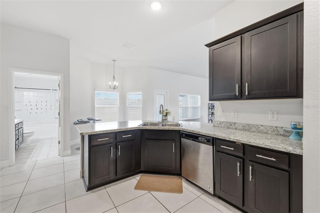 9144 Southeast 47th Court Road Ocala, FL 34480 - Photo 11 of 32 a kitchen with a sink a stove top oven and wooden cabinetry