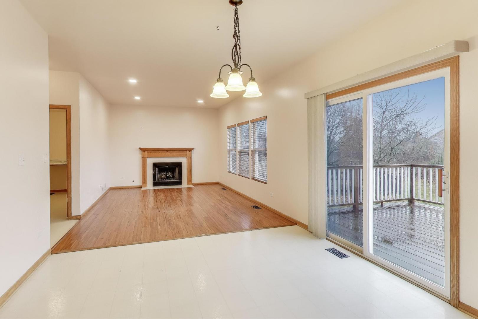 719 Sun Lake Road Lake Villa, IL 60046 - Photo 12 of 46 a view of a livingroom with wooden floor a ceiling fan and windows