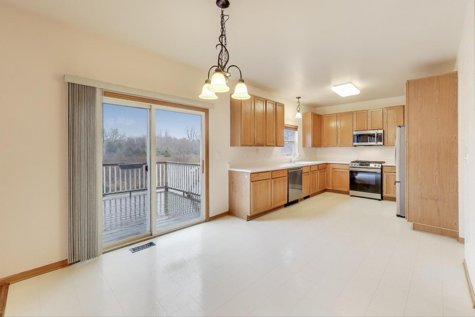 719 Sun Lake Road Lake Villa, IL 60046 - Photo 14 of 46 a view of a kitchen with a sink wooden cabinet and a window