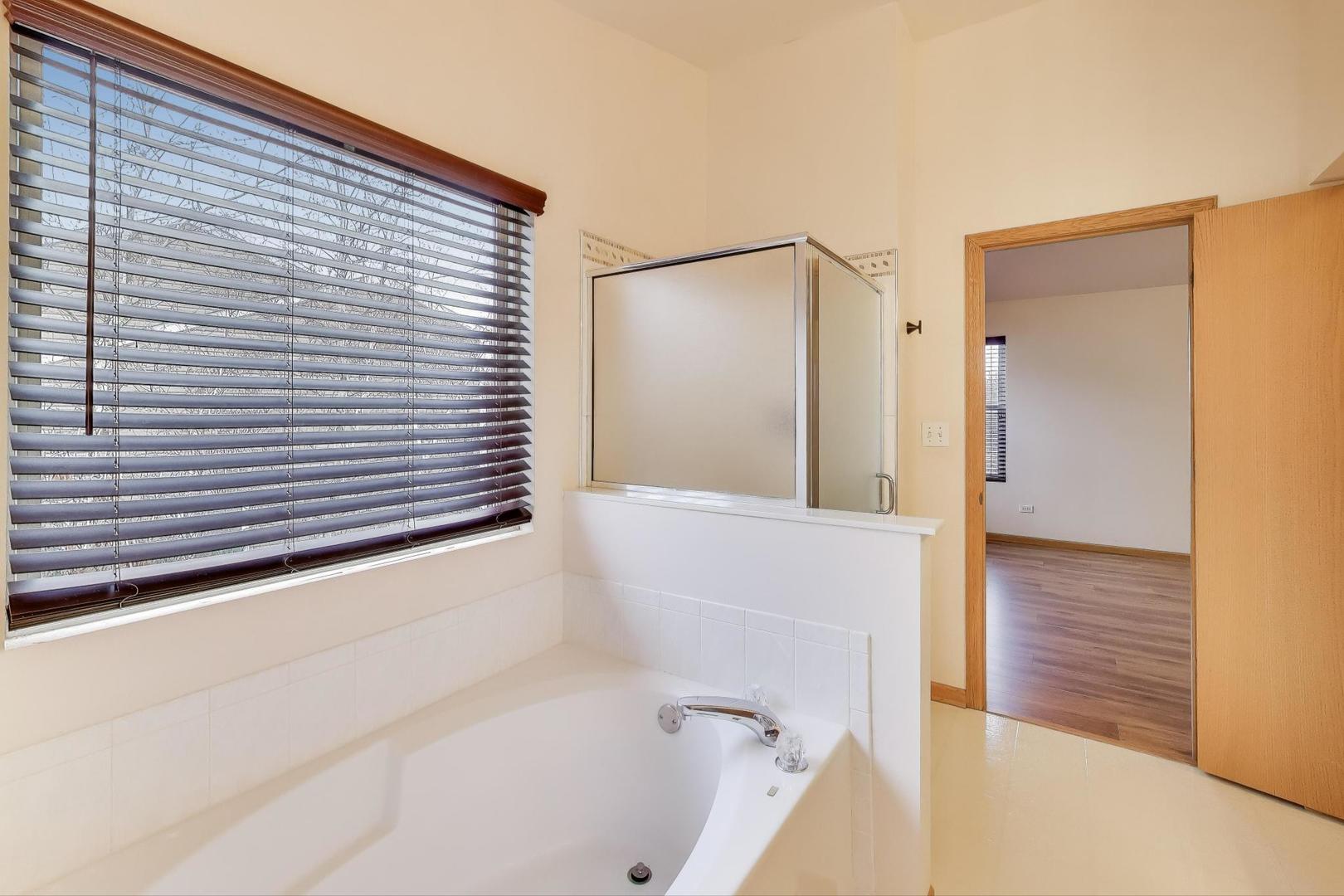 719 Sun Lake Road Lake Villa, IL 60046 - Photo 25 of 46 a bathroom with a bathtub and a shower