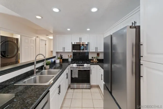 a kitchen that has a sink cabinets counter space and stainless steel appliances