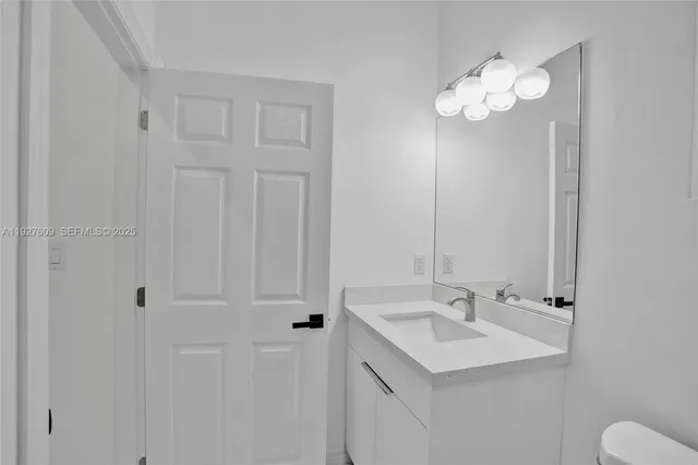 an empty room with a cabinet and mirrors