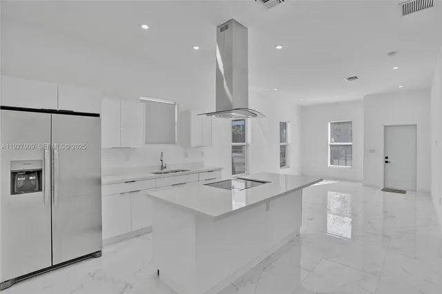 a kitchen with stainless steel appliances granite countertop a refrigerator and a sink