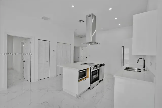 a kitchen with stainless steel appliances granite countertop a sink stove and refrigerator