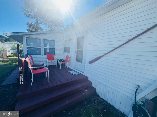 a view of a patio with table and chairs with wooden floor and fence
