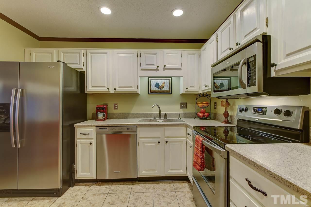 5501 Hamstead Crossing Raleigh, NC 27612 - Photo 11 of 25 a kitchen with stainless steel appliances granite countertop a sink stove and refrigerator