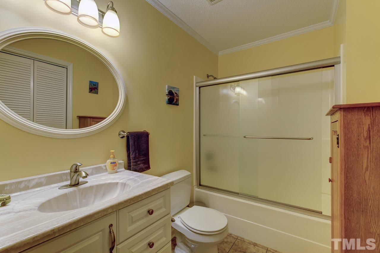 5501 Hamstead Crossing Raleigh, NC 27612 - Photo 18 of 25 a bathroom with a granite countertop sink toilet mirror and shower