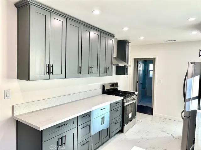 a kitchen with stainless steel appliances a sink stove and a refrigerator