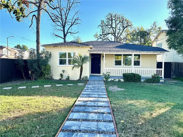 a front view of a house with a garden and yard