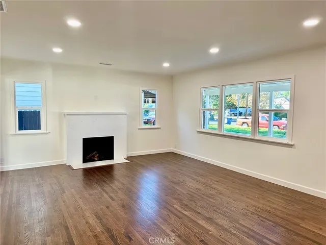 an empty room with windows and fireplace