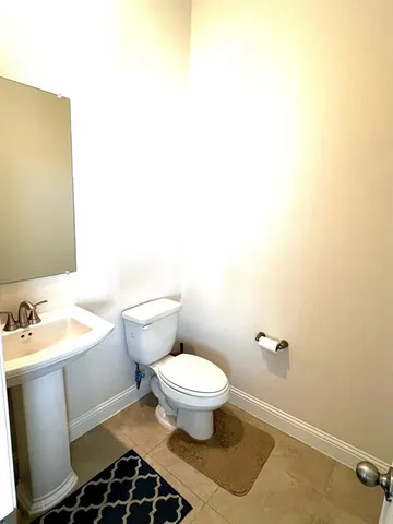 a bathroom with a toilet a sink and a mirror