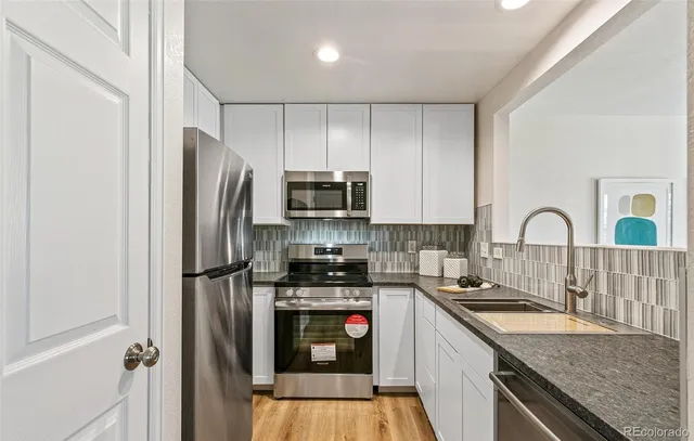 a kitchen with stainless steel appliances granite countertop a refrigerator stove and sink