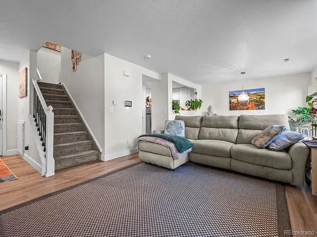 a living room with furniture and wooden floor
