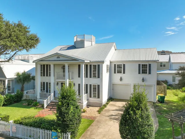 a front view of a house with a garden and yard