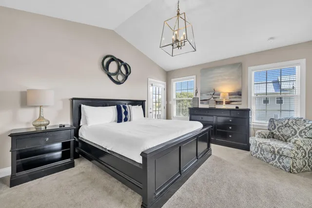 a bedroom with a large bed and a chandelier