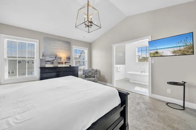 a view of a hallway with wooden floor and a bathroom