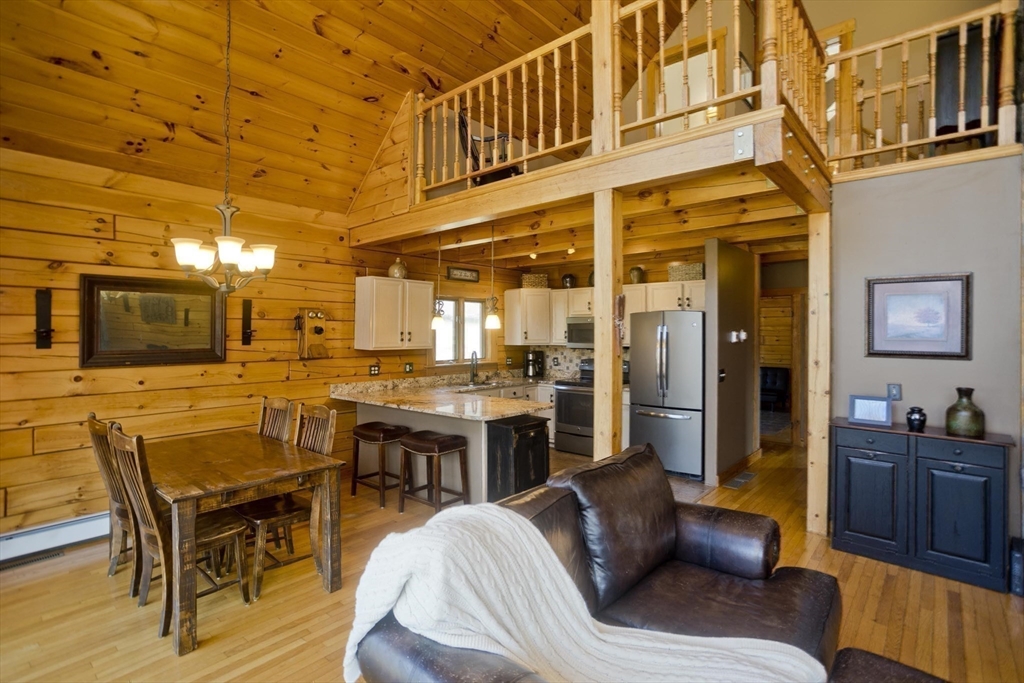 2136 Baptist Hill Road Palmer, MA 01069 - Photo 19 of 41 a living room with furniture a flat screen tv and kitchen view