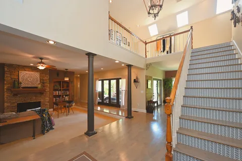 a kitchen with stainless steel appliances granite countertop a refrigerator a sink dishwasher a dining table and chairs with wooden floor