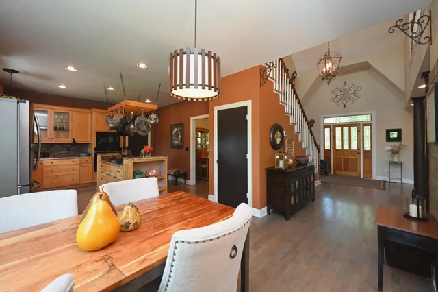 a kitchen with stainless steel appliances granite countertop a stove a sink a refrigerator and a wooden floors