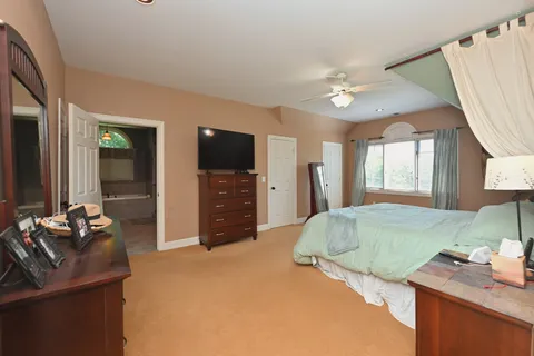 a aerial view of a house next to a big yard and large trees